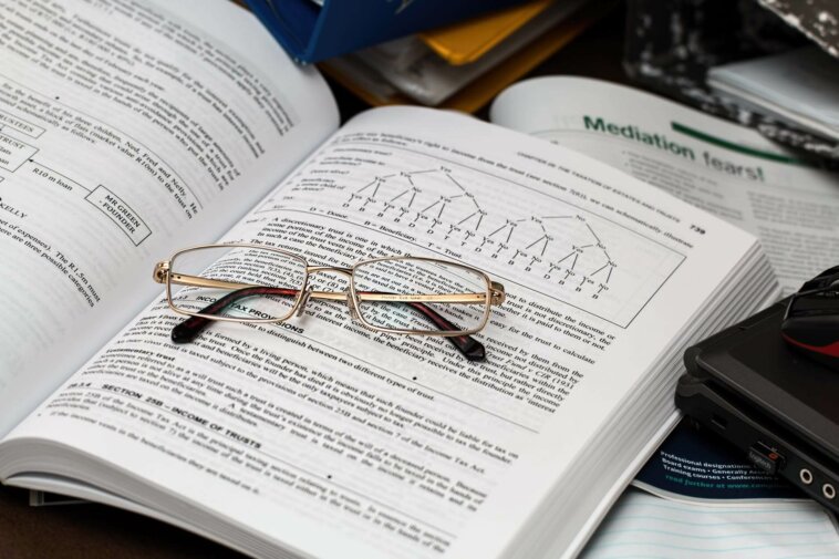 óculos sobre livro de matemática que explica conceitos de fatoração