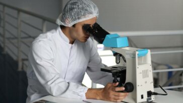 homem observando microscópio